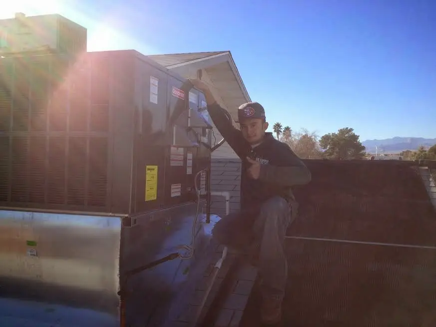HVAC technician performing HVAC Inspection on a rooftop unit in Monroeville